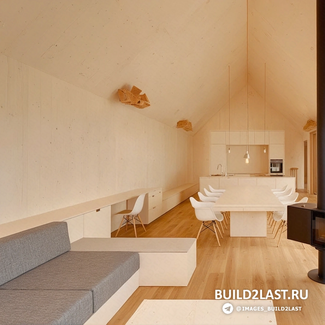 Просторная гостиная с камином и панорамными окнами в деревянном доме в Баварии